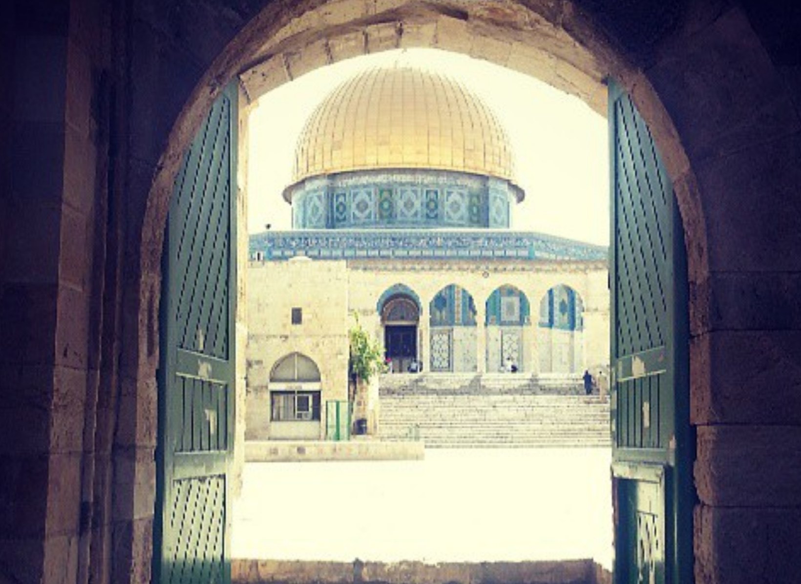 The Dome of the Rock framed by an arch in the Old City of Jerusalem.