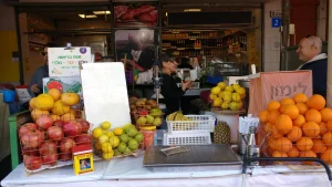 A fruit and juice stall piled with oranges, lemons and pomegranates at a covered market