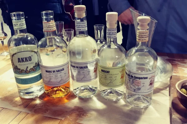 Bottles of Akko gin and Galilee eau de vie lined up on a wooden tasting table