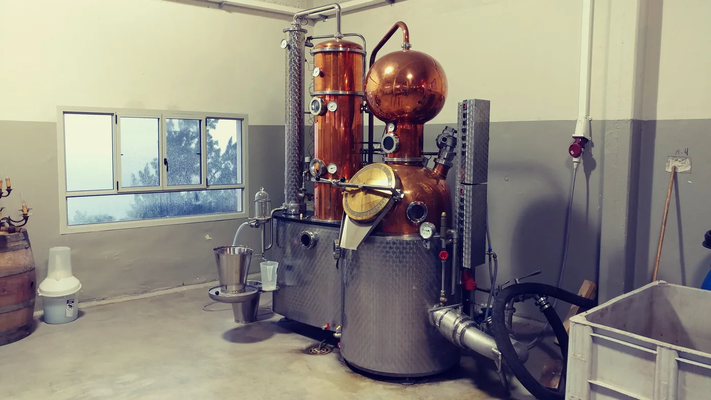 Copper and steel distilling equipment inside a converted factory building