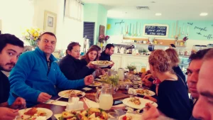 A tour group seated around a table eating lunch at the Marag cafe in Kfar Vradim