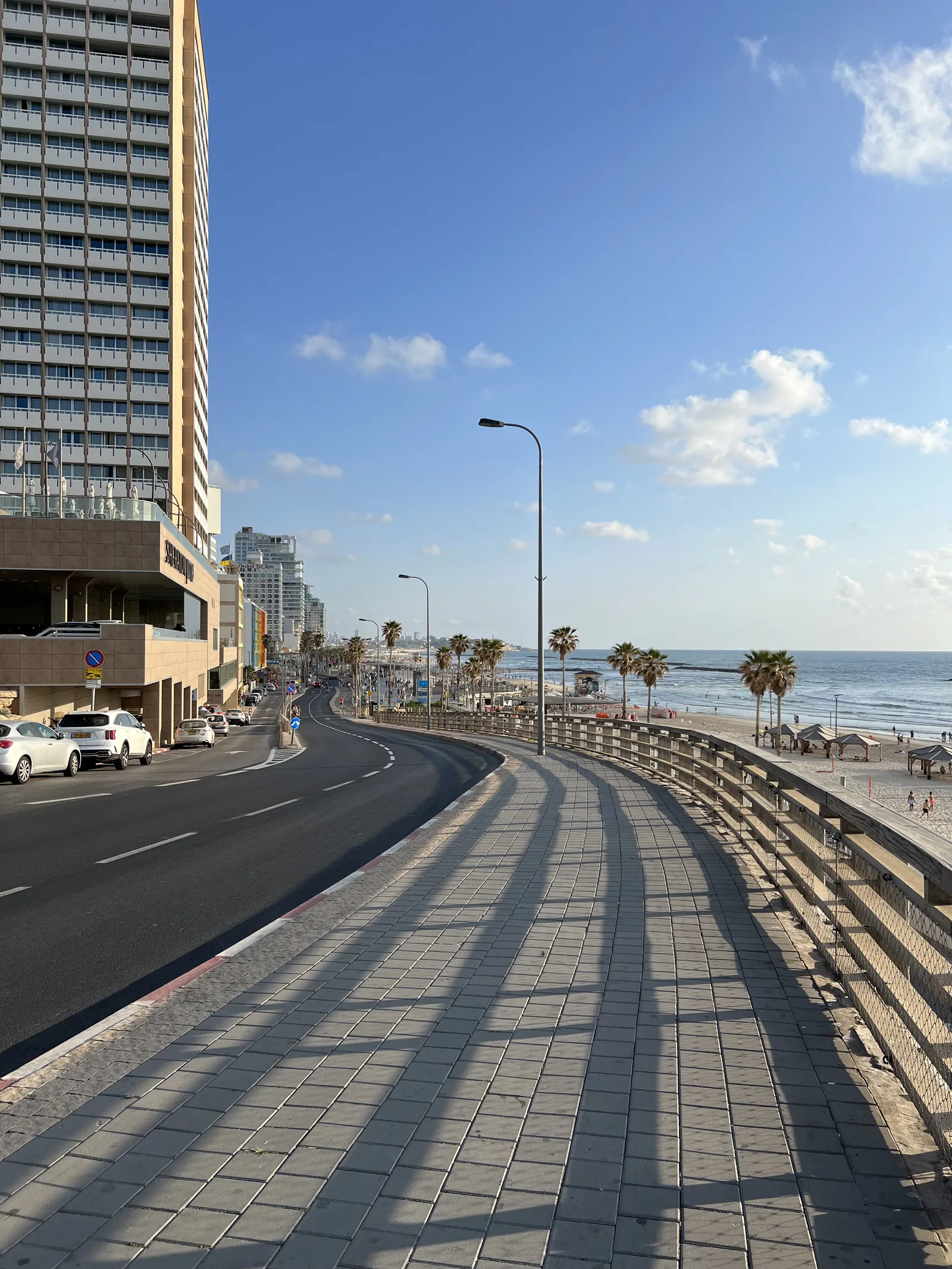 The Tel Aviv beachfront promenade curving south towards Jaffa, with the Mediterranean alongside.