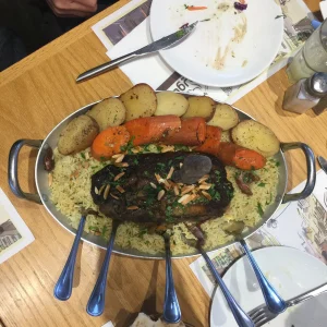 An overhead view of a large platter of spiced rice topped with slow-cooked lamb