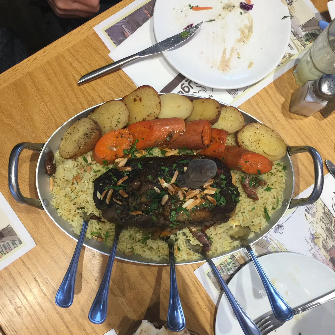 An overhead view of a large platter of spiced rice topped with slow-cooked lamb