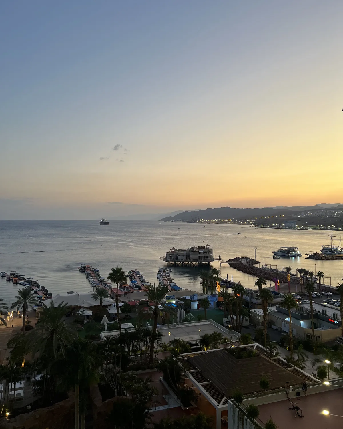 Sunset over the Eilat marina and the Red Sea, with boats moored below the hotels.
